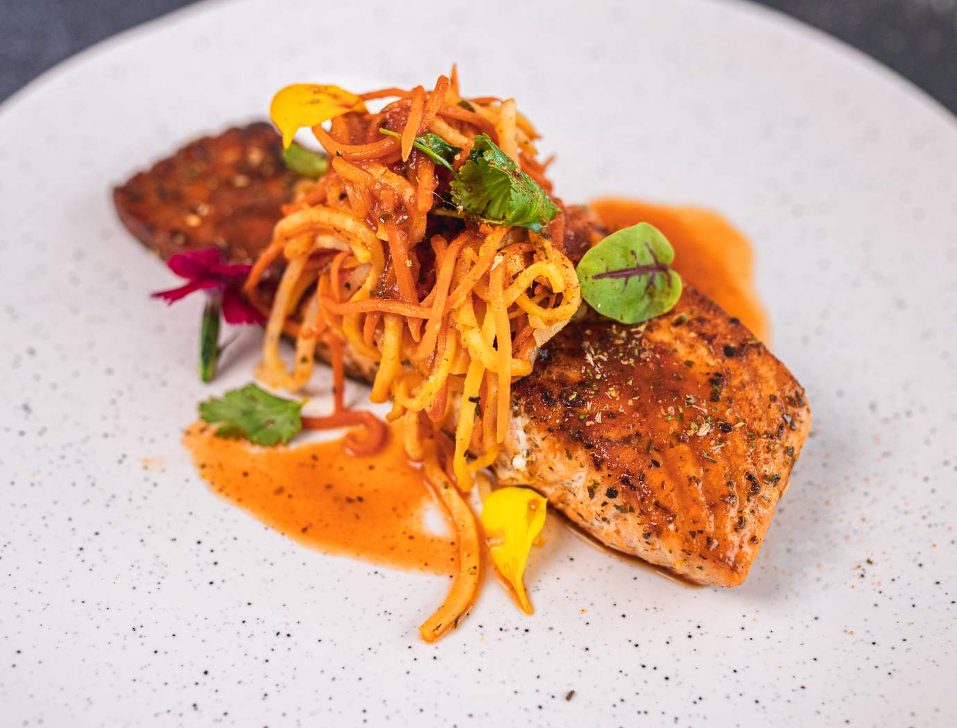 Pan seared salmon with carrot, celeriac julienne and hot sauce