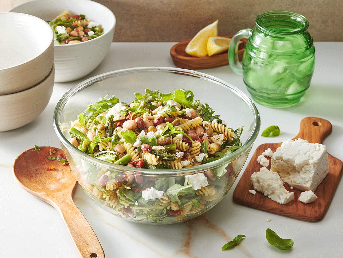 Salade de pâtes avec légumineuses herbes et citron, asperges, roquette et vinaigrette au basilic